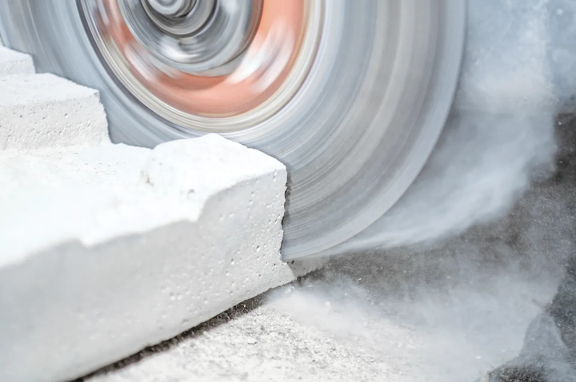 Trennsäge beim Schneiden eines Betonsteins mit Staubentwicklung